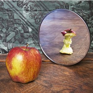 surrealistic picture of an apple reflecting in the mirror