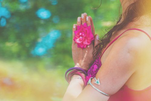 Woman holds her hands in prayer over her heart