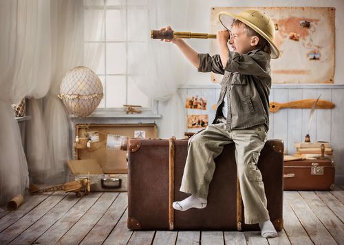 Little boy peering through a telescope