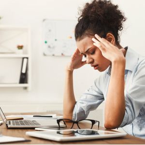 Tired african-american business woman with headache at office