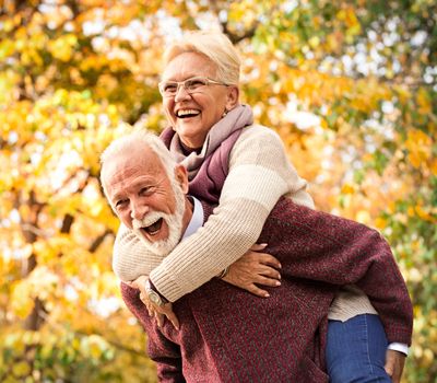 Senior couple laughing and having fun in autumn park. After all these years as at the first meeting 