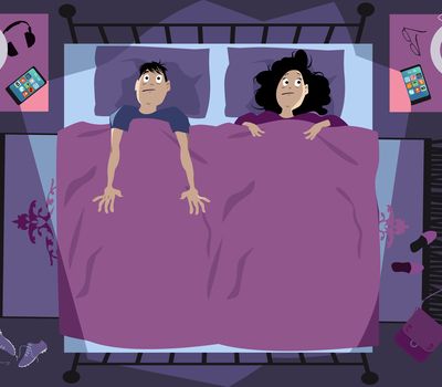 Insomniac young couple laying in bed late at night