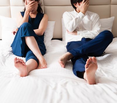 Couple in bed looking upset