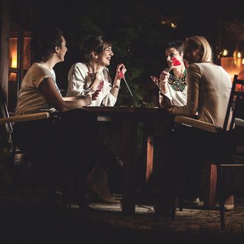 Four women friends having dinner together and laughing