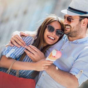 Happy couple having date and eating ice cream after shopping