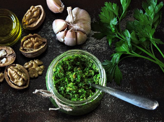 Pesto of parsley and almonds in a glass jar on a wooden table