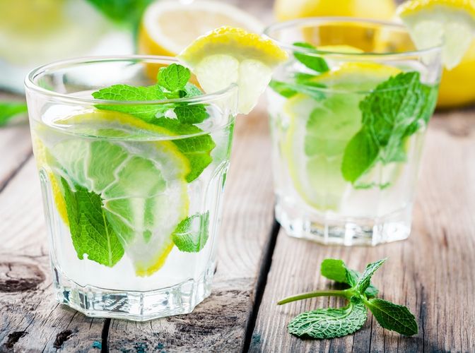 summer iced drink with lemon and mint on wooden rustic table