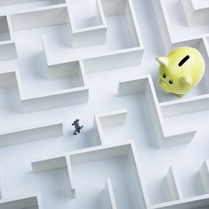 Businessman searching for piggy bank hidden inside a maze