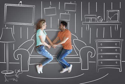 Couple holding hands against furniture background