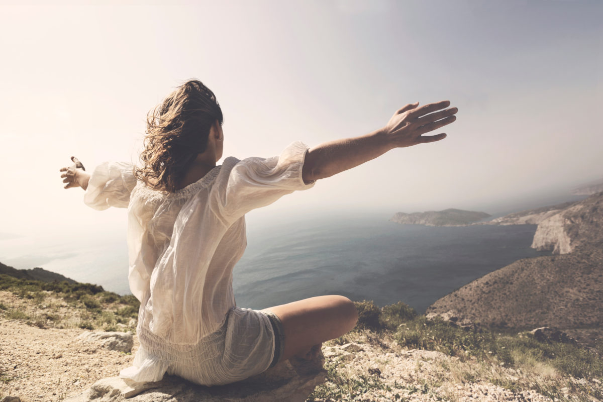 woman taking a breath in front of a spetacular view