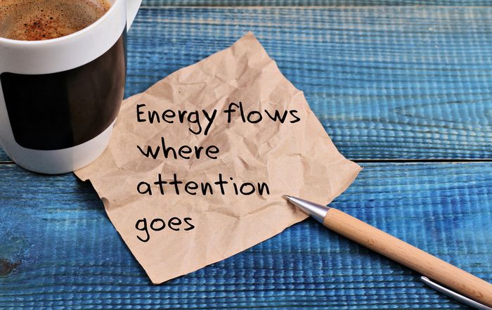 Words written on napkin that say Energy flows where attention goes