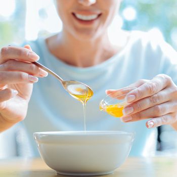 Smiling female adding sweetness to the porridge