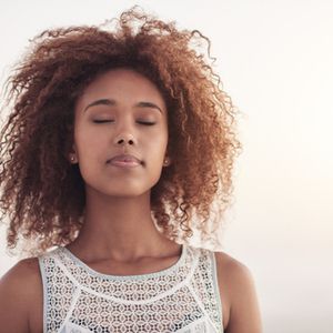 Young african american woman with eyes closed taking a breath