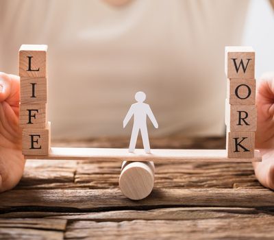 Close-up Of A Human Hand Protecting Balance Between Life And Work On Seesaw