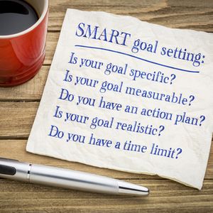 tips and questions on SMART goal setting - handwriting on a napkin with a cup of coffee