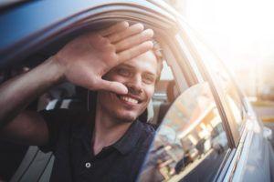 guy waving out of the car window passionately